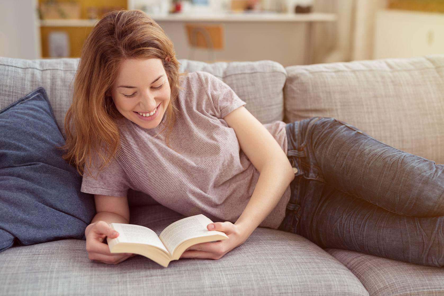 She reads in the evening. Woman read on Sofa. Beauty reading on Sofa. She reads for a bit..