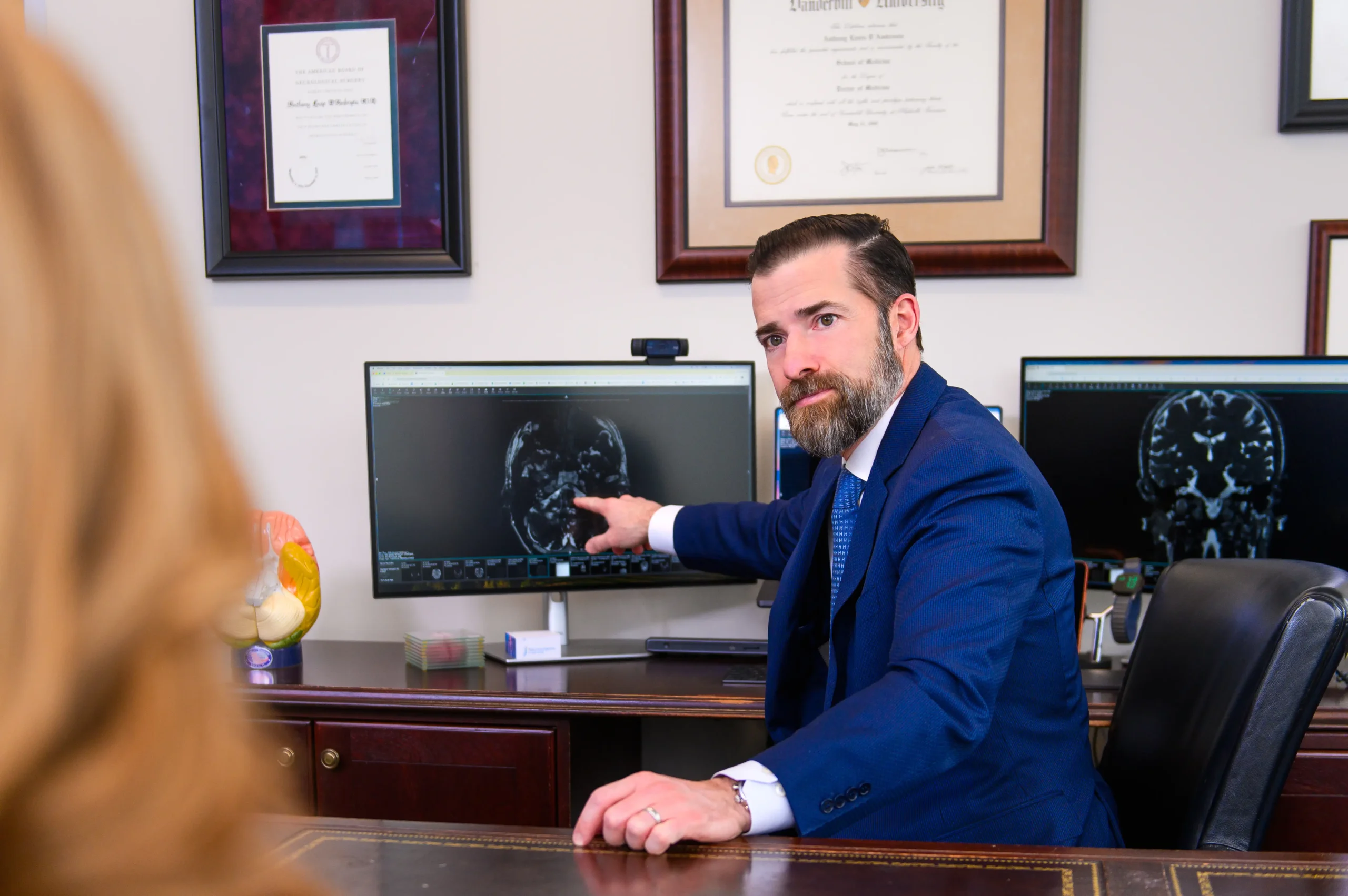 Nationally recognized, skull base certified Neurosurgeon, Dr. Anthony D'Ambrosio reviews a scan of a patient who has Hemifacial Spasm with that patient.