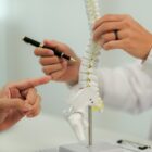 Doctor consulting with a patient suffering from back pain, offering guidance and treatment options for spinal care.