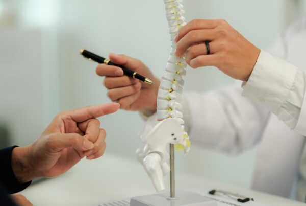 Doctor consulting with a patient suffering from back pain, offering guidance and treatment options for spinal care.